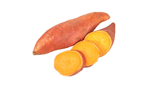 Sweet potato or sweetpotato whole and sliced tubes with red skin and yellow flesh isolated on white. Vegetable food staple.
