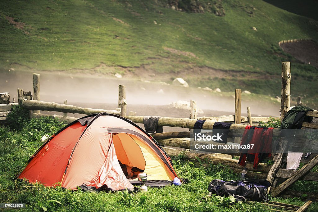 Acampamento para barraca perto de um vilarejo nas montanhas envoltas em brumas - Foto de stock de Acampar royalty-free