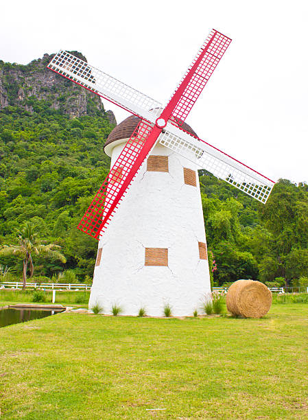 istock Windmill, hay roll, green field and canal. view in farm. 179028742