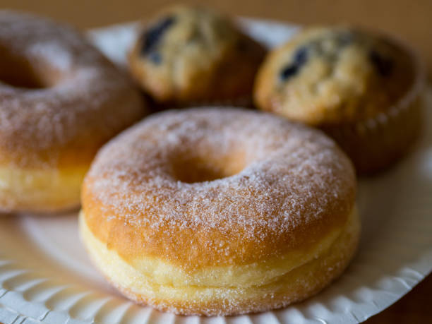 istock Sugar donut on white paper plate with other cakes. 1790294383
