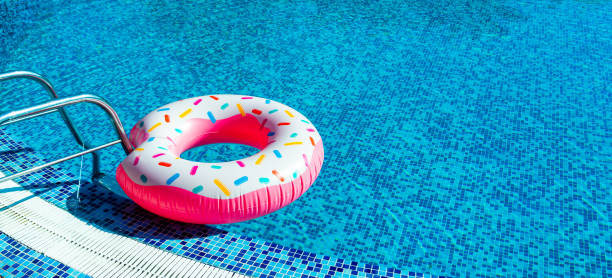 istock A toy rubber bitten donut with caramel sprinkles next to the pool railing 1790297209
