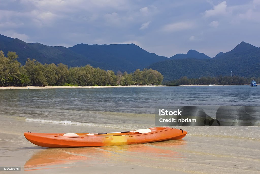 Orange kayak on the beach with blue mountain Orange kayak on the beach with blue mountain in Thailand Bay of Water Stock Photo