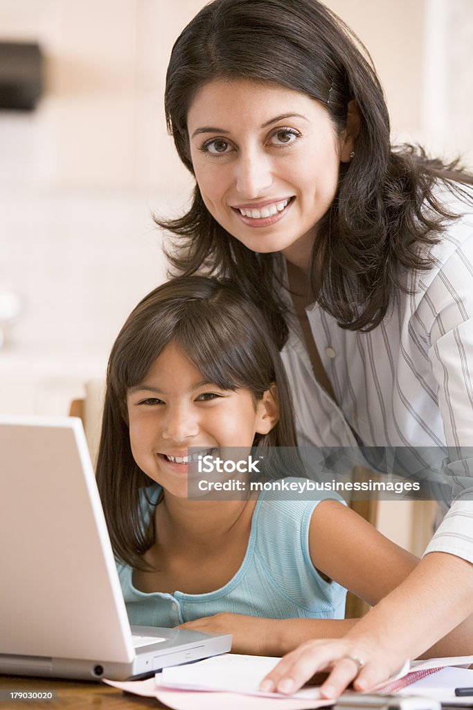 Menina mulher e jovem na cozinha com o computador portátil a sorrir - Royalty-free Família Foto de stock