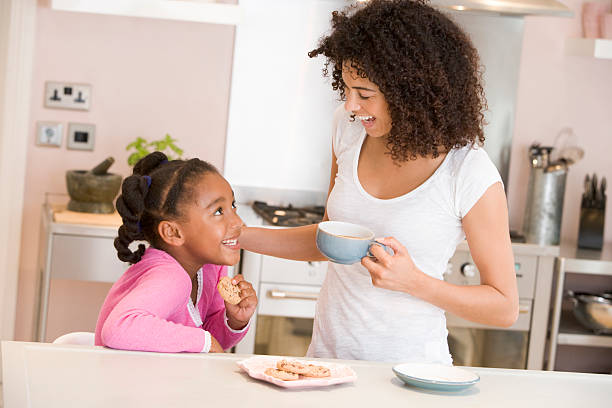 femme et jeune fille dans la cuisine avec les cookies - cookie mother 30s parent photos et images de collection