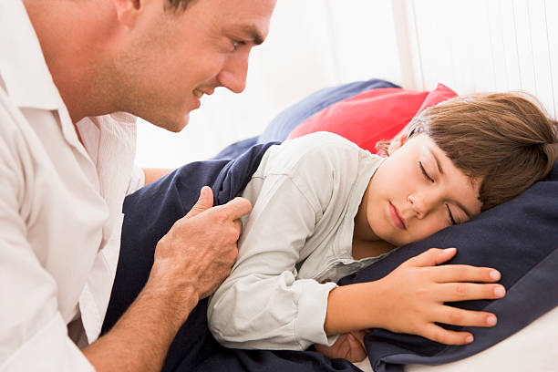 istock Man waking young boy in bed smiling 179030397