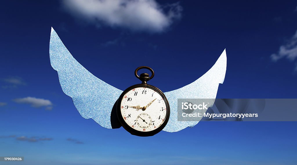 Time flies An old watch with wings flies in the sky Alarm Clock Stock Photo