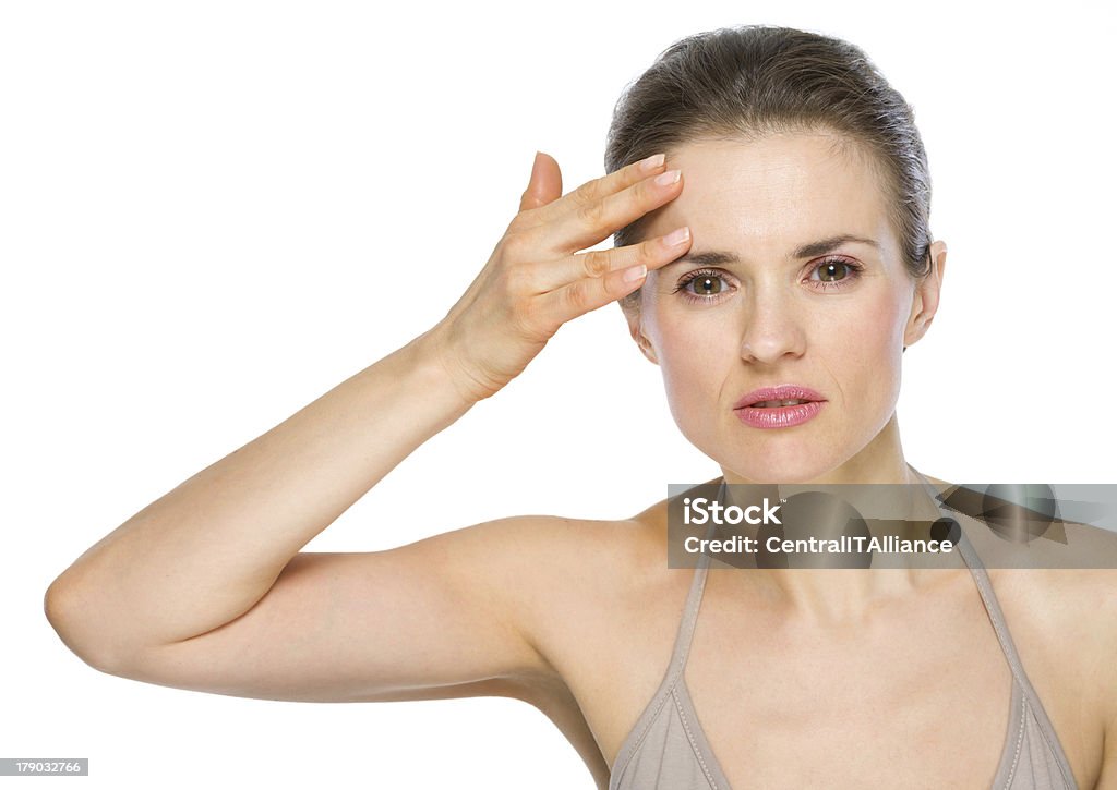 Bellezza Ritratto di giovane donna controllando la pelle del viso - Foto stock royalty-free di Adulto