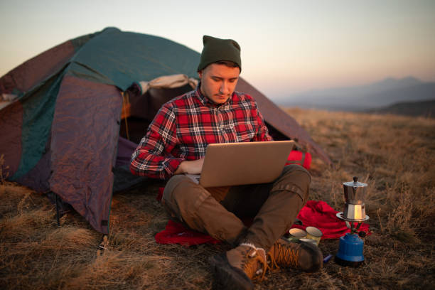 istock Young hiker working from his camp at forest stock photo 1790330402