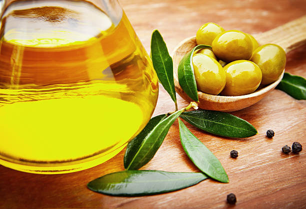 istock Olive oil with fresh olives on rustic wood 179033421