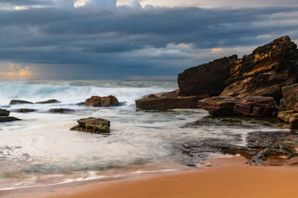istock Sunrise seascape with low clouds and waves 1790341355