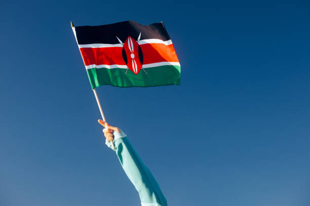 istock Hand Waiving a Kenyan Flag on a Blue Sky 1790347723