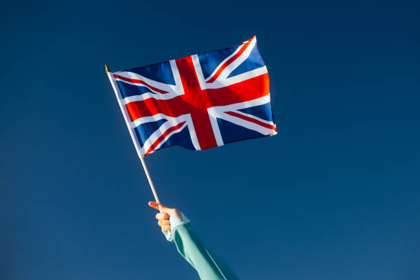 istock Hand Waiving a Union Flag on a Blue Sky 1790348080