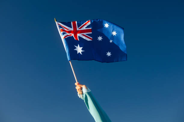 istock Hand Waiving an Australian Flag on a Blue Sky 1790348609