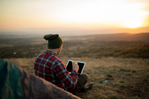istock Young handsome man having a coffee while working from his camp in a forest stock photo 1790354457