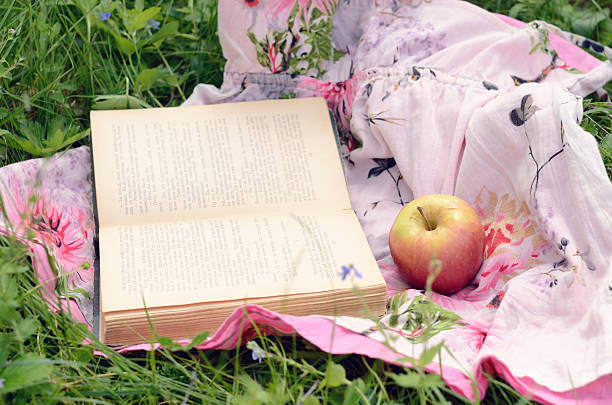 istock Apple and open book in green grass 179036262