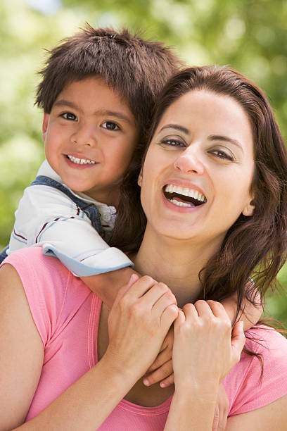istock Woman and young boy embracing outdoors smiling 179039040