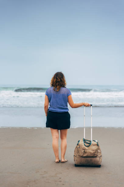 istock Woman with a bag in a beach 1790398770
