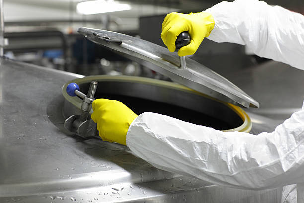 istock hands in yellow gloves opening industrial process tank 179042738