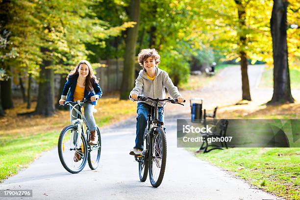 Boy And Girl Riding Bicycles In The Citys Park Stock Photo - Download Image Now - Boys, Cycling, Public Park