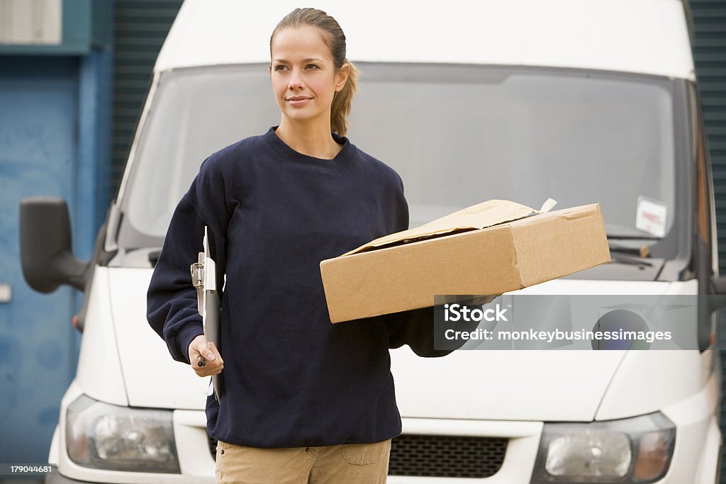 Repartidor de pie con van, portapapeles y caja - Foto de stock de Furgoneta de Reparto libre de derechos