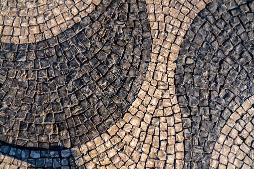 Black and white mosaic calcada cobblestone sidewalk and road, Lisbon, Portugal