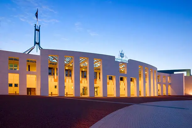 Australian Parliament House illuminated at twilight. Slight motion blur on flag due to long exposure. More Australia