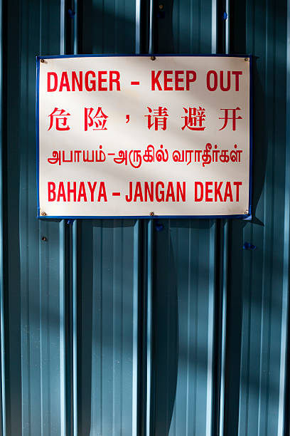 istock Danger keep out sign against blue metal in four languages 179047825