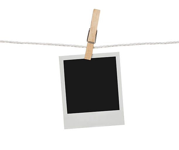 Blank photograph on the clothesline Blank photograph hanging on the clothesline isolated on white background with clipping path for the inside of the frame drying photos stock pictures, royalty-free photos & images