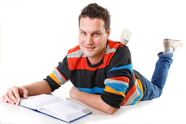 istock young man reading a book on the floor isolated 179050705