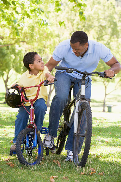 istock Man and young boy on bikes outdoors smiling 179051530