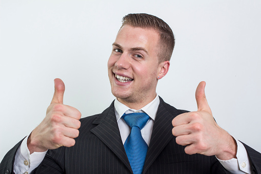 a young business man thumbs up isolated on white.