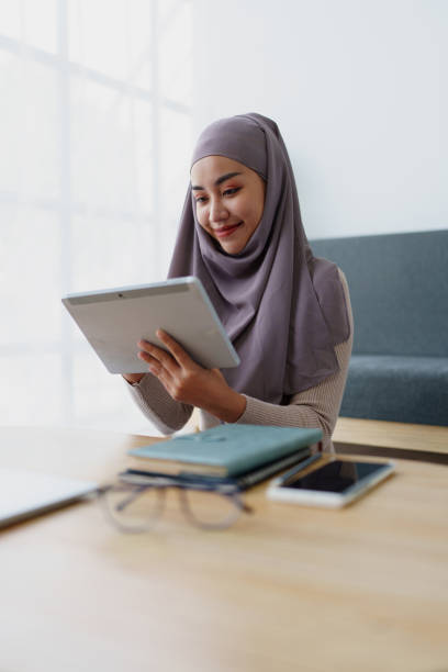 istock Female Muslim employee uses tablet to work at office. 1790525814