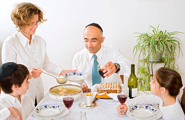 jewish family celebrating passover father mother son and daughter in seder celebrating passover passover celebration stock pictures, royalty-free photos & images