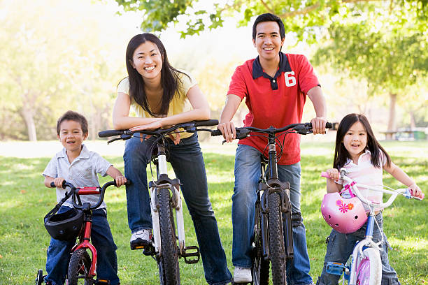 Family on bikes outdoors smiling. Looking at camera.