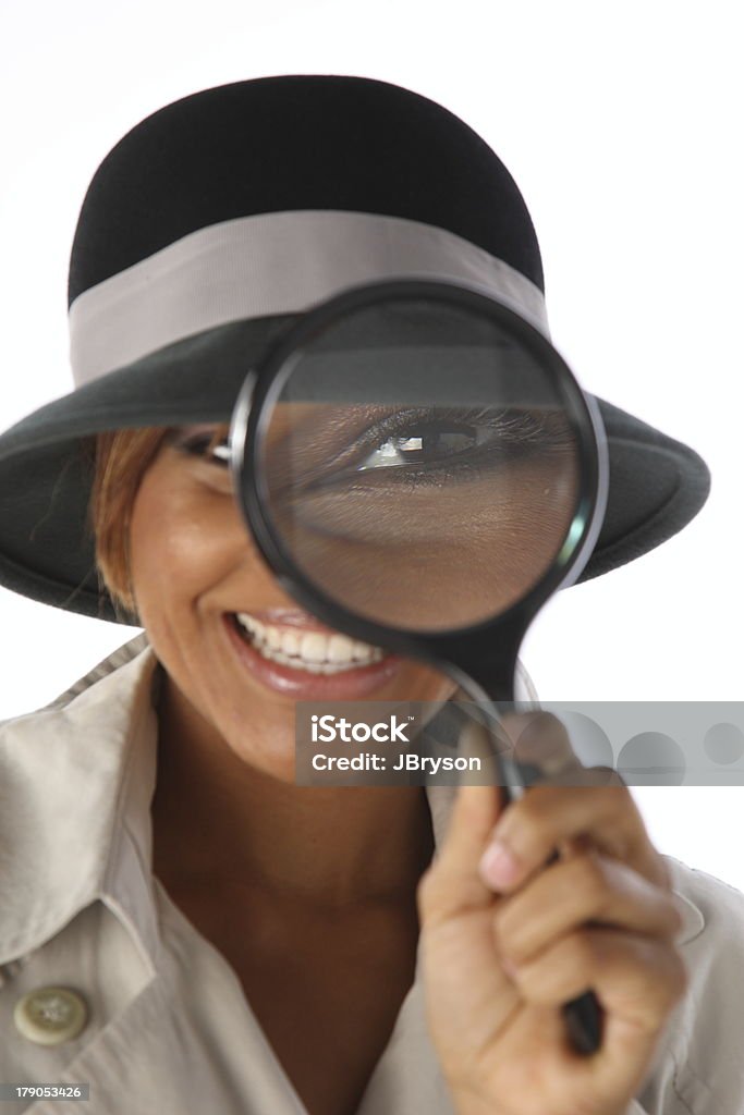 Black Woman Detective Looking for Clues "Young adult black woman detective, looking for clues. Her eye is distorted by the magnifying glass." 25-29 Years Stock Photo