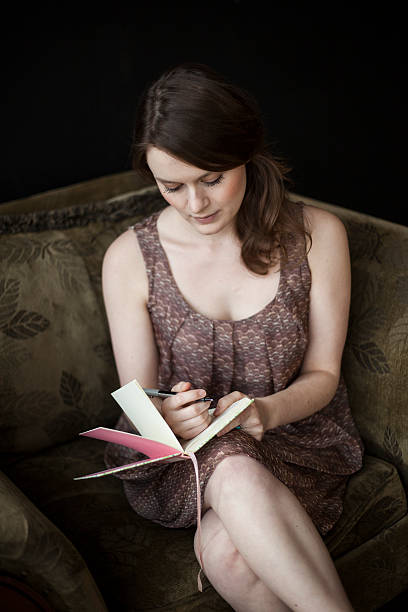 istock Young Woman Writing in Her Journal 179054681