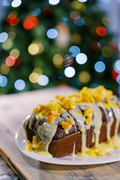 istock Chocolate stollen covered with icing and mandarin pieces stands on the table 1790550161