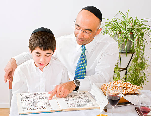 padre e figlio in onore di pasqua ebraica - seder passover judaism family foto e immagini stock