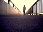 Lonely Girl walking along Bridge