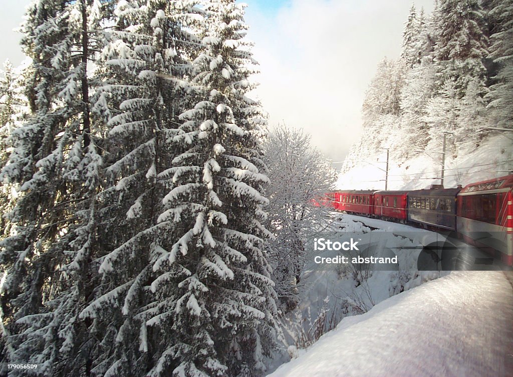 Swiss Train Travelling through Alps in Winter View from inside a Swiss Train as it turns around a Snow Covered Mountain Train - Vehicle Stock Photo