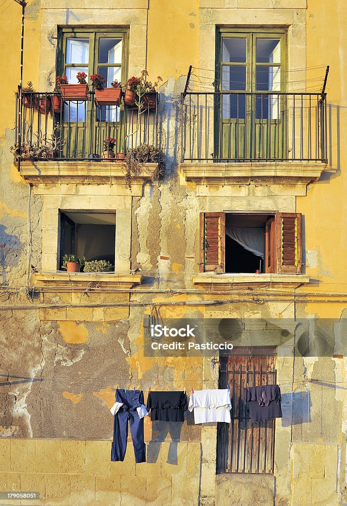 Old italian street with windows, doors, balcony and washing "Washing hanging in street in Syracuse, Sicily, Italy.For similar images please see the lightbox:" Abstract Stock Photo
