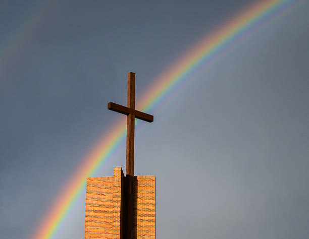 istock Rainbow in the sky behind a wooden cross 179058285