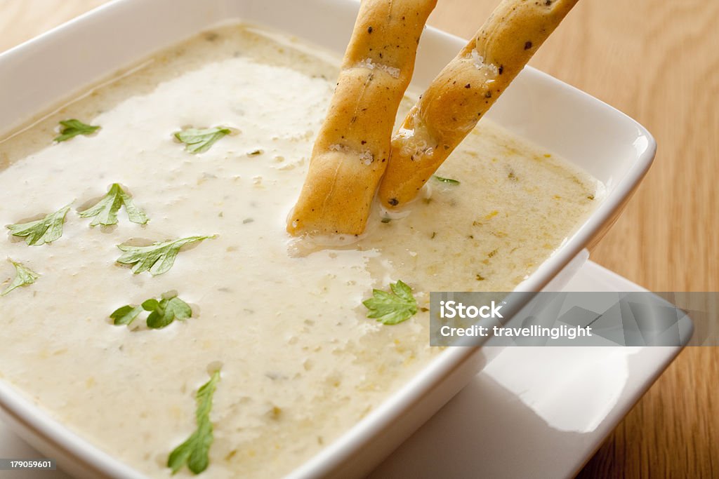 Celery Soup with Breadsticks "Celery soup garnished with parsley, in a square white bowl, with breadsticks, and copy space. More soup:-" Bowl Stock Photo