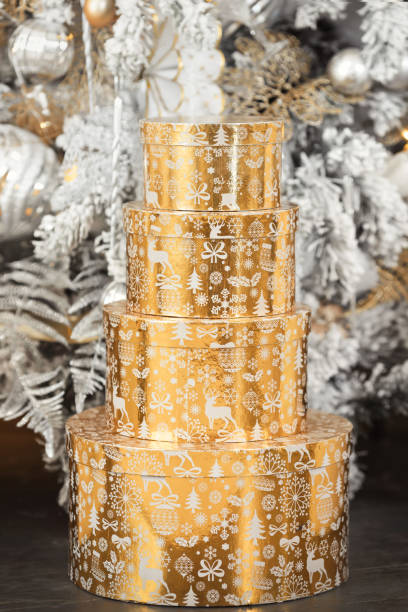 istock Creative pyramid of winter present for new year. Luxury golden tower from gift boxes under beautiful christmas tree. Winter holidays mood 1790597503