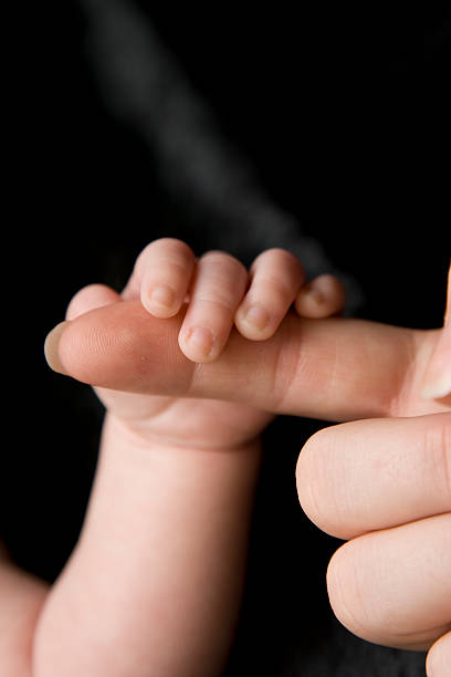 istock Baby Holding Mother's Finger 179060232