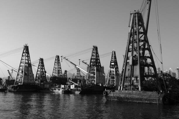 Cranes at Hong Kong harbor, viewed from the waterfront promenade in West Kowloon cultural district. Hong Kong.