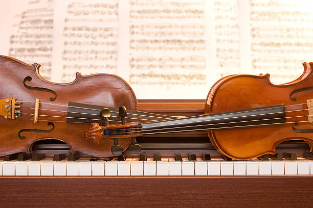 2 violins en las teclas del piano - foto de stock