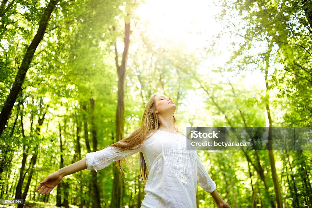 A women in the woods basking in the sun Enjoying the sun Women Stock Photo
