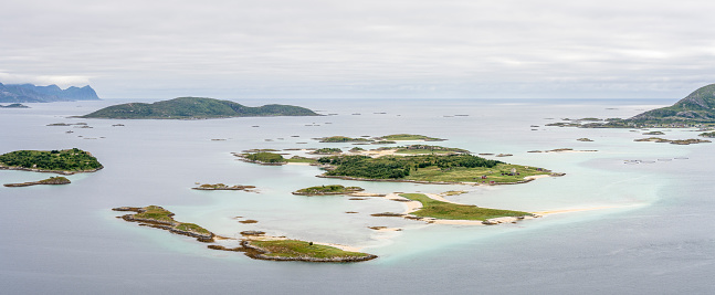 Beautiful small archipelago and shallow turquoise waters near the island of Sommarøa on a cloudy day, Tromsø Municipality in Troms og Finnmark county,  Northern Norway