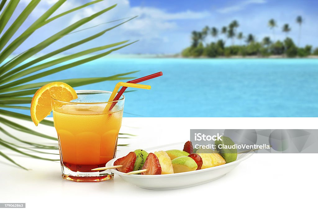 summer cocktail and fruit skewers summer cocktail and fruit skewers on exotic seascape Beach Stock Photo